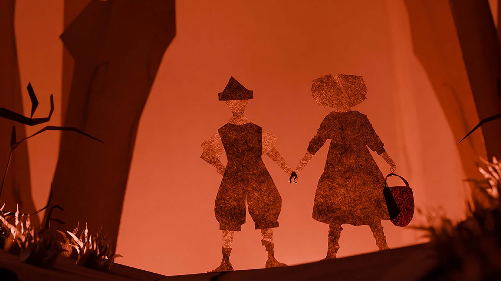 Two silhouetted figures in period costume stand together against a warm orange backdrop in a stylised theatrical scene.
