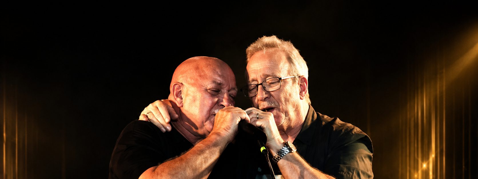 Swanee Swan strips back the hits for an intimate night at The Gov - Two performers share a microphone on stage, lit by warm golden spotlights during an intimate venue show.