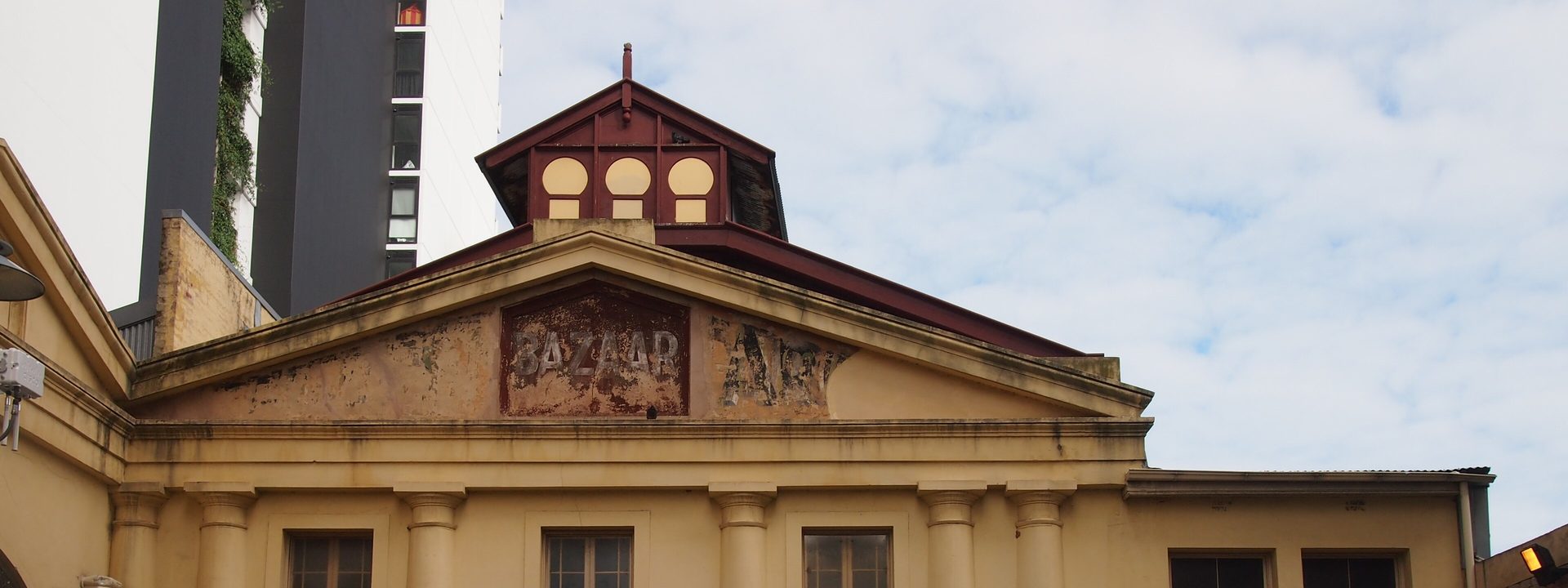 The Queens Theatre - Historic cream-coloured building with columned facade, domed roof cupola, and arched entrance doorway.