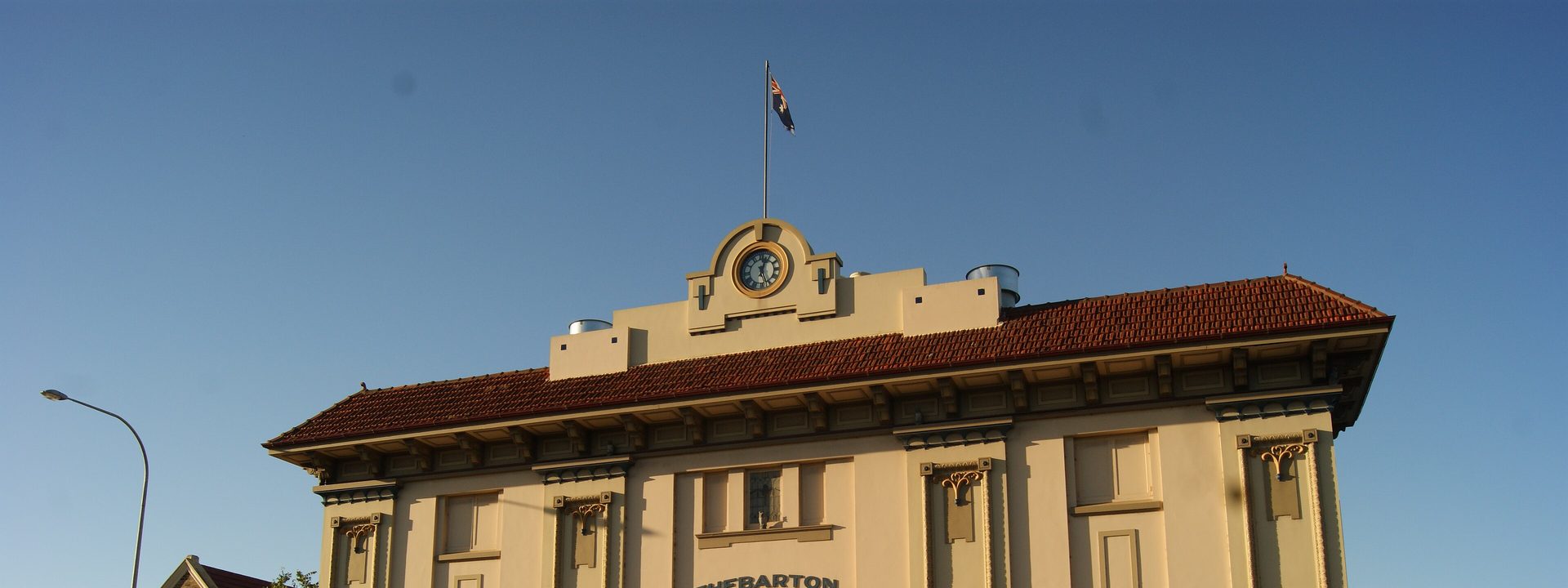 Thebarton Theatre - A heritage theatre building with cream and brown facade stands on a street corner under clear blue sky.