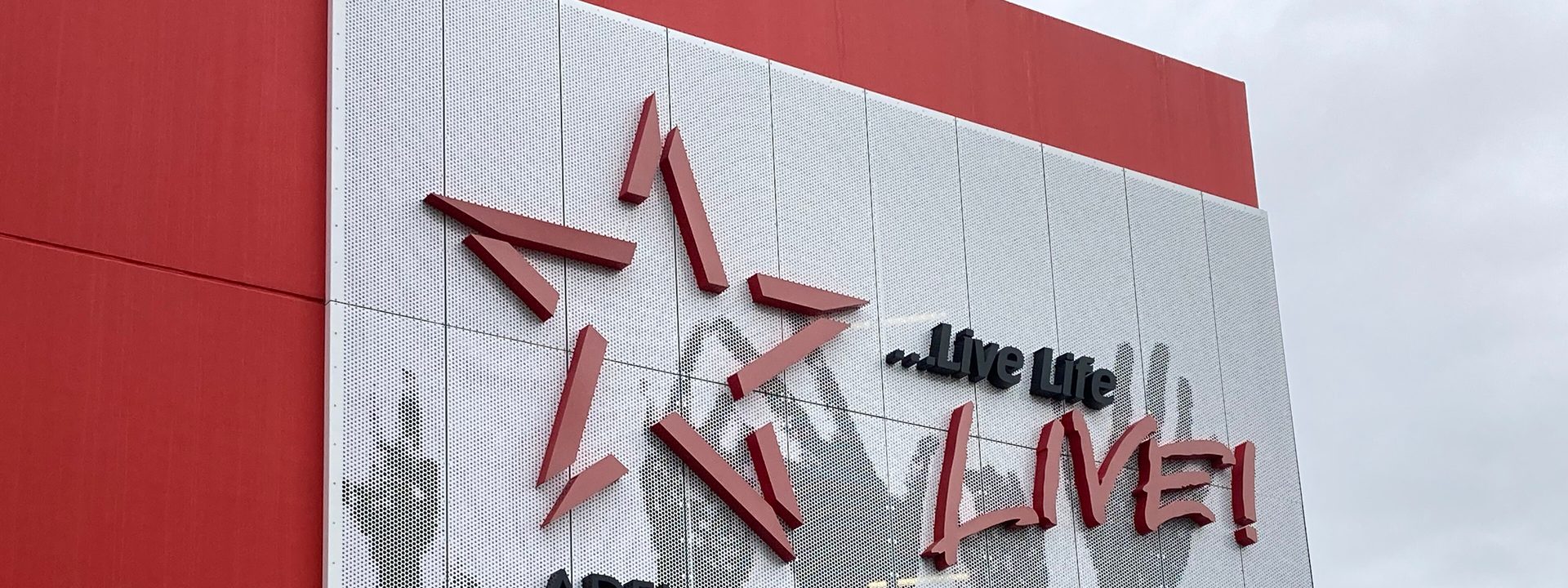 Adelaide Entertainment Centre Arena - Red and white building facade displays Adelaide Entertainment Centre signage with artistic graphic design.