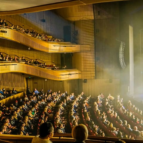 The King of Pop Show - Audience fills the balconies and stalls of Her Majesty's Theatre during a performance on the illuminated stage.