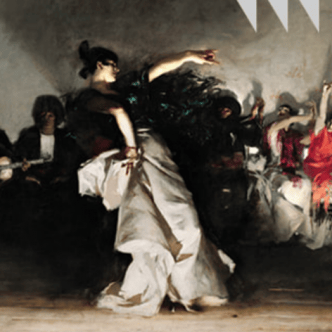 Fire & Fiesta - Dancer in white and black costume mid-leap surrounded by performers in dark clothing on stage.