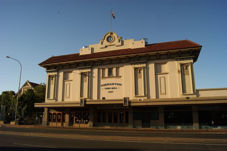 Thebarton Theatre - A heritage theatre building with cream and brown facade stands on a street corner under clear blue sky.