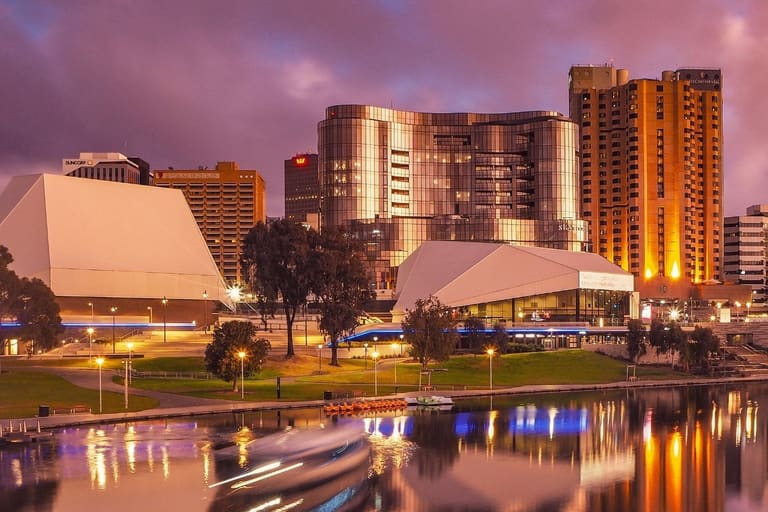 Adelaide Festival Centre - Modern cultural buildings and high-rise residential towers illuminate the Adelaide riverbank at twilight.