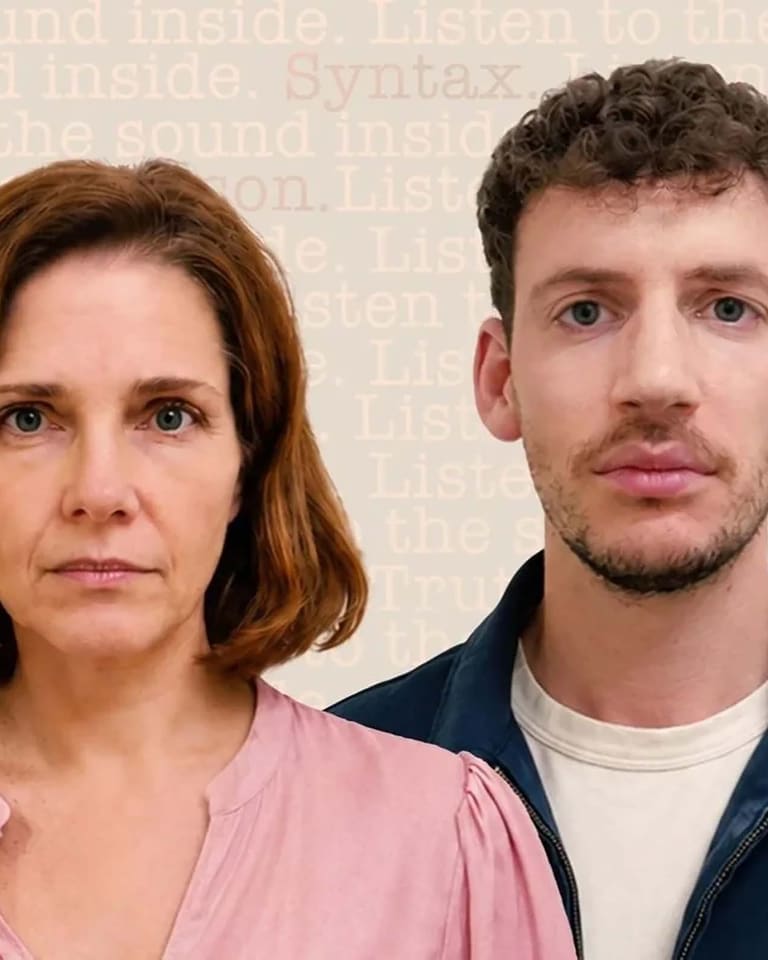Woman in pink shirt and man in navy jacket face the camera against a neutral beige background.