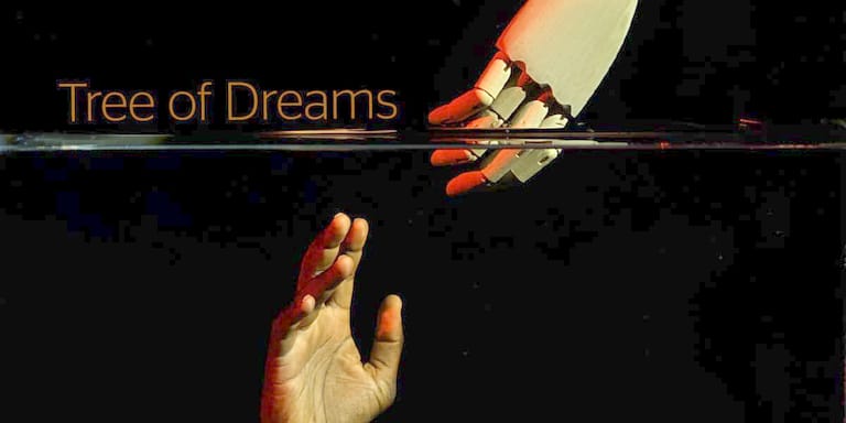 Two hands reach upward toward each other against a dark background with "Tree of Dreams" text illuminated above.