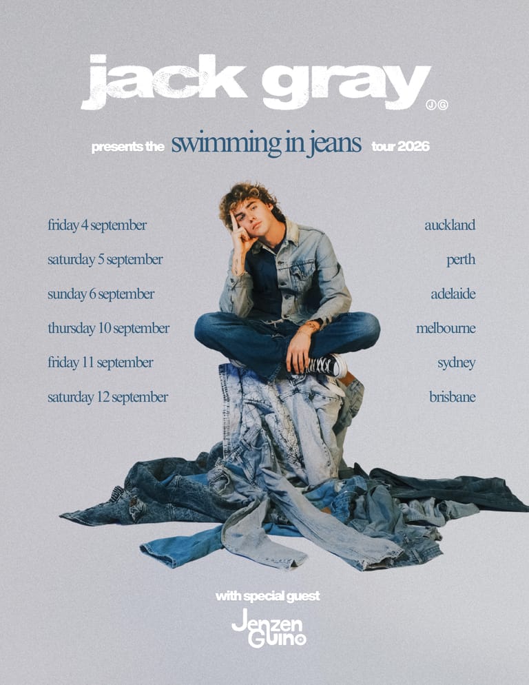 Man in denim shirt sitting on pile of blue jeans against grey background with tour dates listed.
