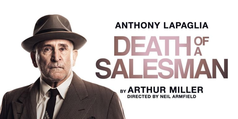Middle-aged man in fedora and dark suit against white background with production text.