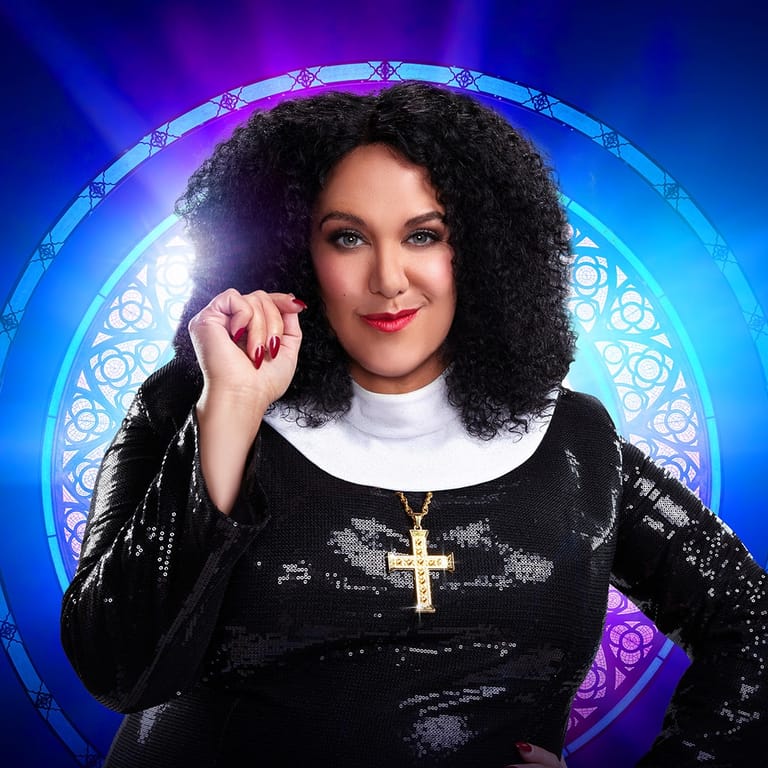 Woman with voluminous dark curly hair wearing black sequined jacket with cross necklace against glowing purple and blue circular backdrop.