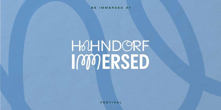 Hahndorf Immersed festival logo with flowing blue abstract shapes and white text.