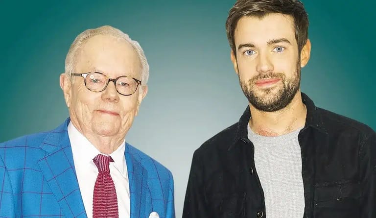Two men stand against a turquoise background: an older man in blue checked blazer and glasses, and a younger man in black jacket.