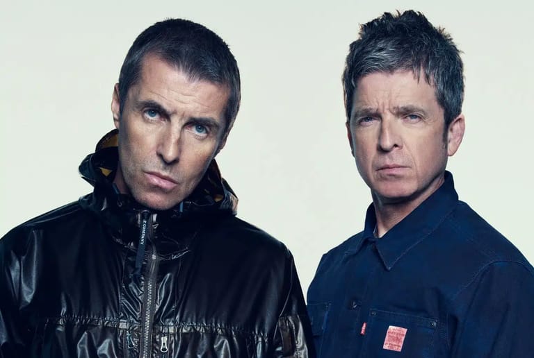 Two men in black and navy jackets pose against a neutral background.