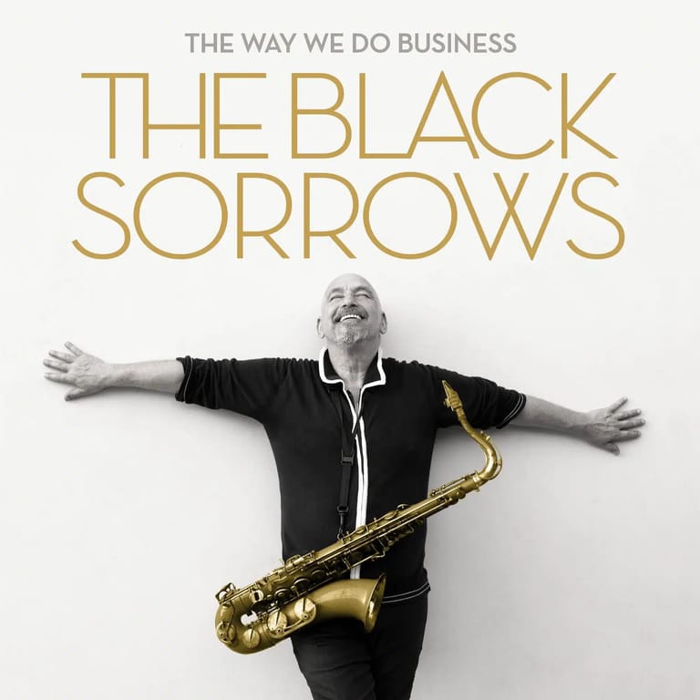 Man in black shirt with arms outstretched holding a gold saxophone against white background.