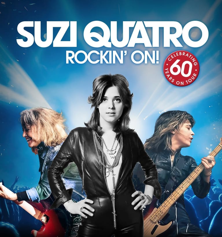 Suzi Quatro in black leather jacket with band members on blue-lit stage for 60th anniversary tour.