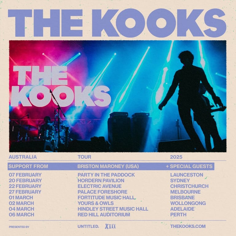 Silhouetted performer on stage facing neon-lit "The Kooks" signage during a 2025 Australian tour.