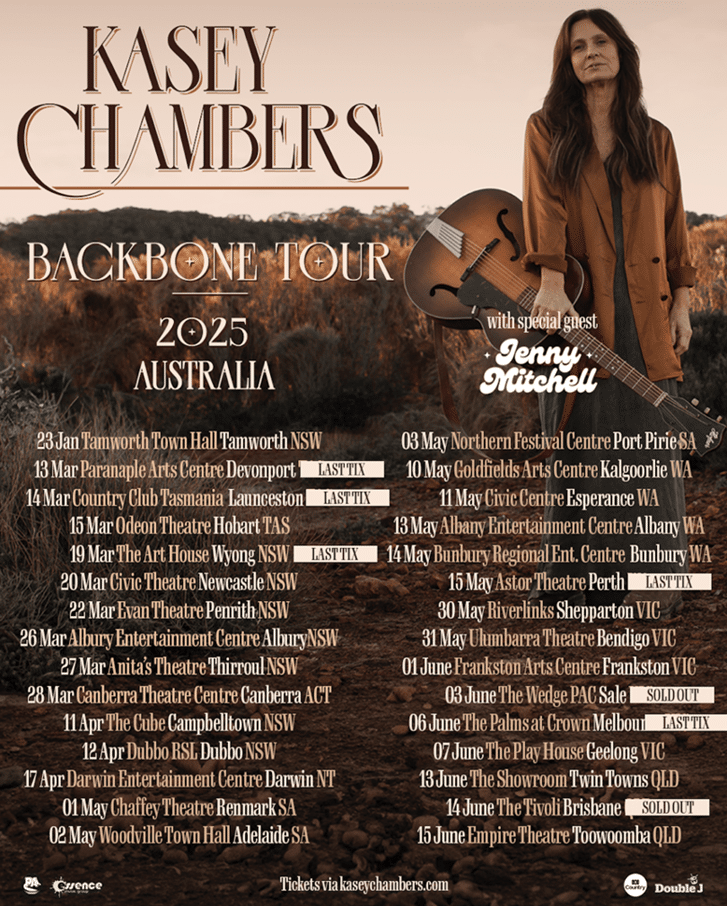 Kasey Chambers stands in a warm-toned landscape wearing a brown jacket, promoting her 2025 Backbone Tour across Australian venues.