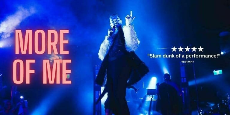 Performer on stage with arms raised high, lit by blue spotlights, with "MORE OF ME" text displayed beside them.