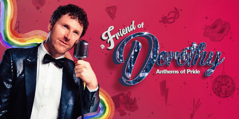 Man in black velvet jacket and bow tie holding microphone against vibrant pink "Friend of Dorothy" pride-themed backdrop.