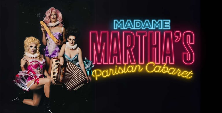 Cabaret performers in colourful costumes pose beneath neon signage for Madame Martha's Parisian Cabaret.