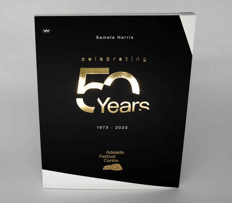 Black book cover with gold lettering celebrating 50 years, 1973–2023, featuring Samela Harris.