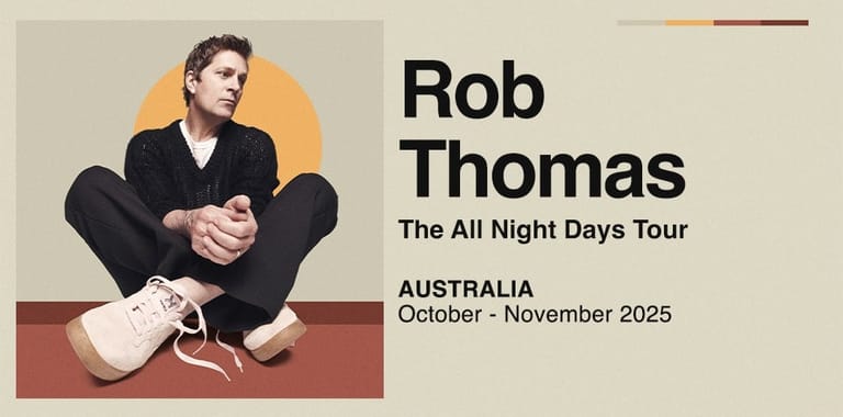 Man in black suit seated against warm-toned backdrop with tour dates listed beside him.