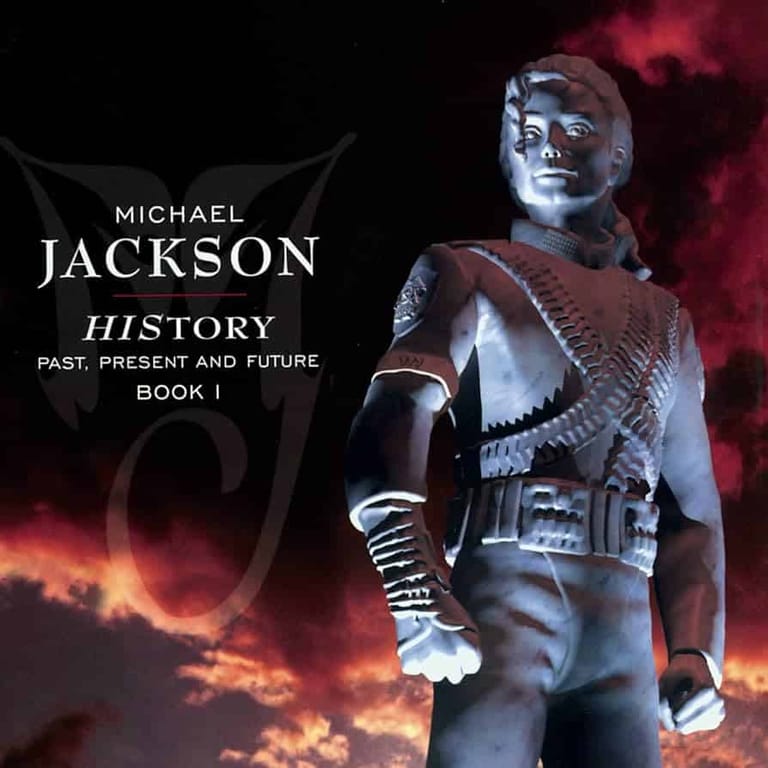 Holographic figure in metallic costume posed against fiery red and orange atmospheric lighting with "Michael Jackson History" text overlay.