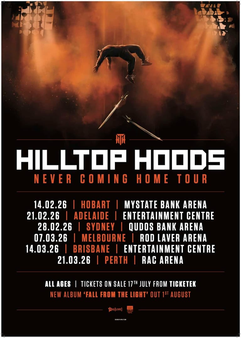 Silhouetted figure balancing on a beam amid orange dust and smoke during a concert tour promotion.