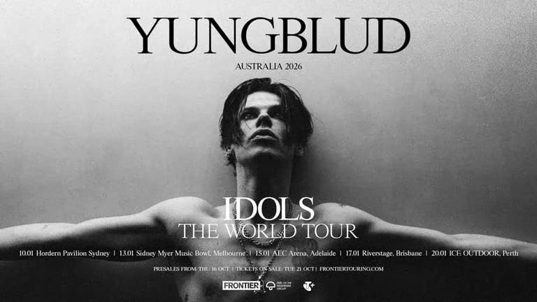 Shirtless male performer with long dark hair and sunglasses against textured grey background, advertising world tour.