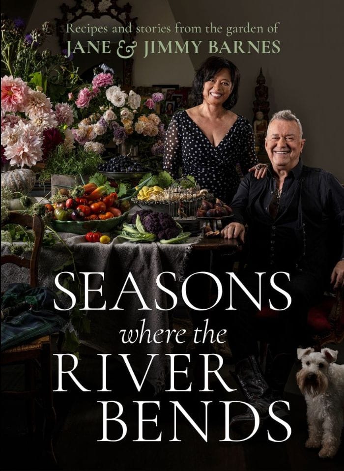 Two people stand beside seasonal produce and flowers, displayed on a table with fresh vegetables and blooms, for the book cover "Seasons where the River Bends".