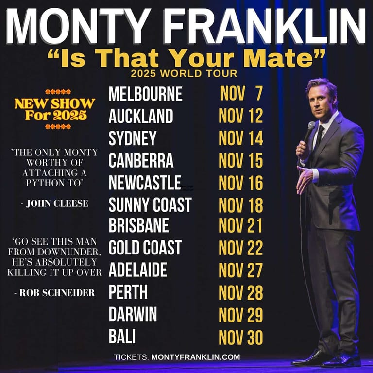 Monty Franklin stands in a dark suit holding a microphone on stage, promoting his "Is That Your Mate" world tour across Australian and international cities.