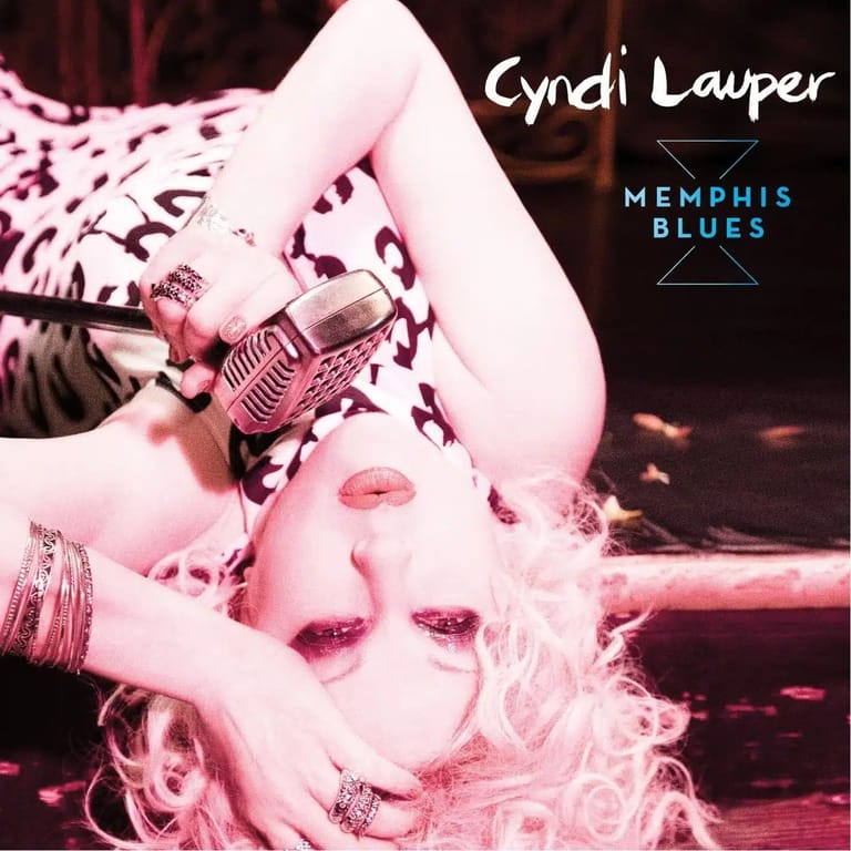Singer Cyndi Lauper posed against pink-tinted imagery with jewellery and dramatic makeup for Memphis Blues album cover.