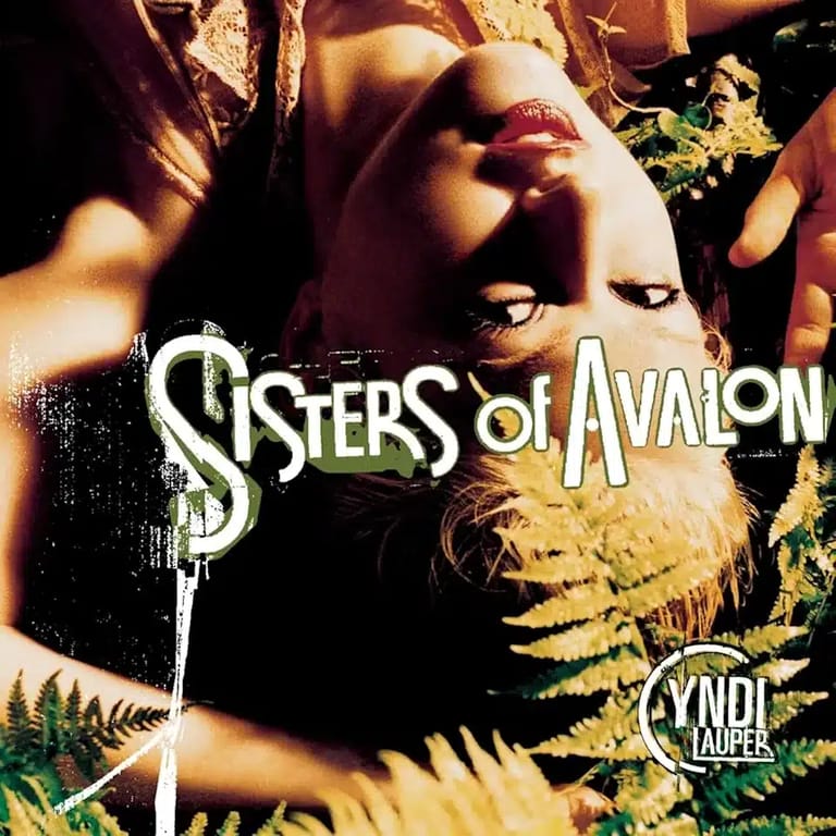 Sisters of Avalon album cover featuring a woman's face overlaid with golden foliage and band typography.
