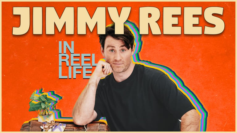 Comedian Jimmy Rees poses thoughtfully against a bright orange background with "In Reel Life" text overlay.