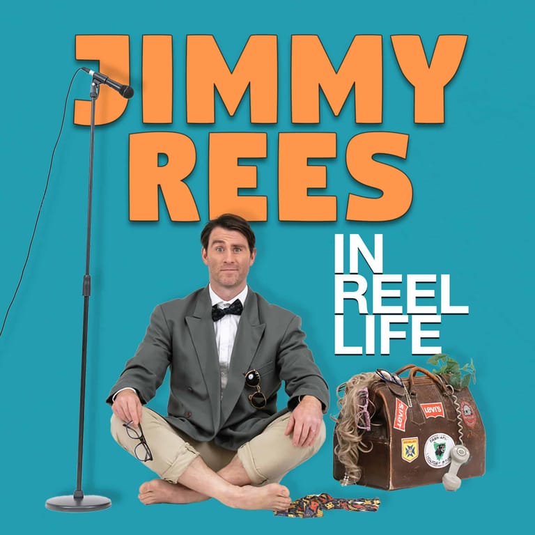 Jimmy Rees sits cross-legged on a turquoise background wearing a grey blazer and bow tie, with a microphone stand and vintage suitcase beside him.