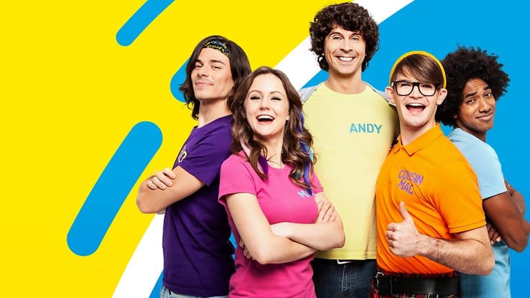 Five young people pose together against a bright yellow and blue geometric background.