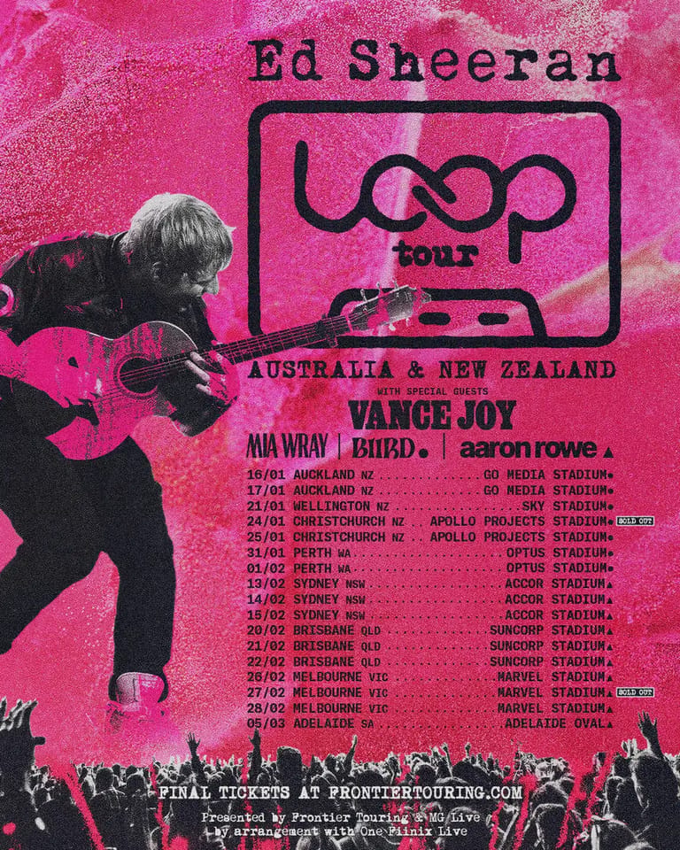 Musician holding acoustic guitar against bright pink tour poster for Ed Sheeran's ÷ Loop tour across Australia and New Zealand.