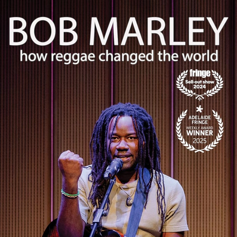 Performer with long dreadlocks holding a microphone on stage against a corrugated backdrop, with show title and festival laurels displayed above.