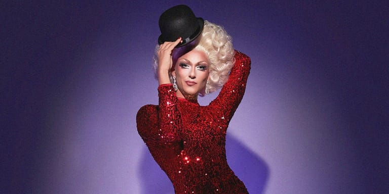 Performer in a sequinned red jacket and black hat poses against a purple background.