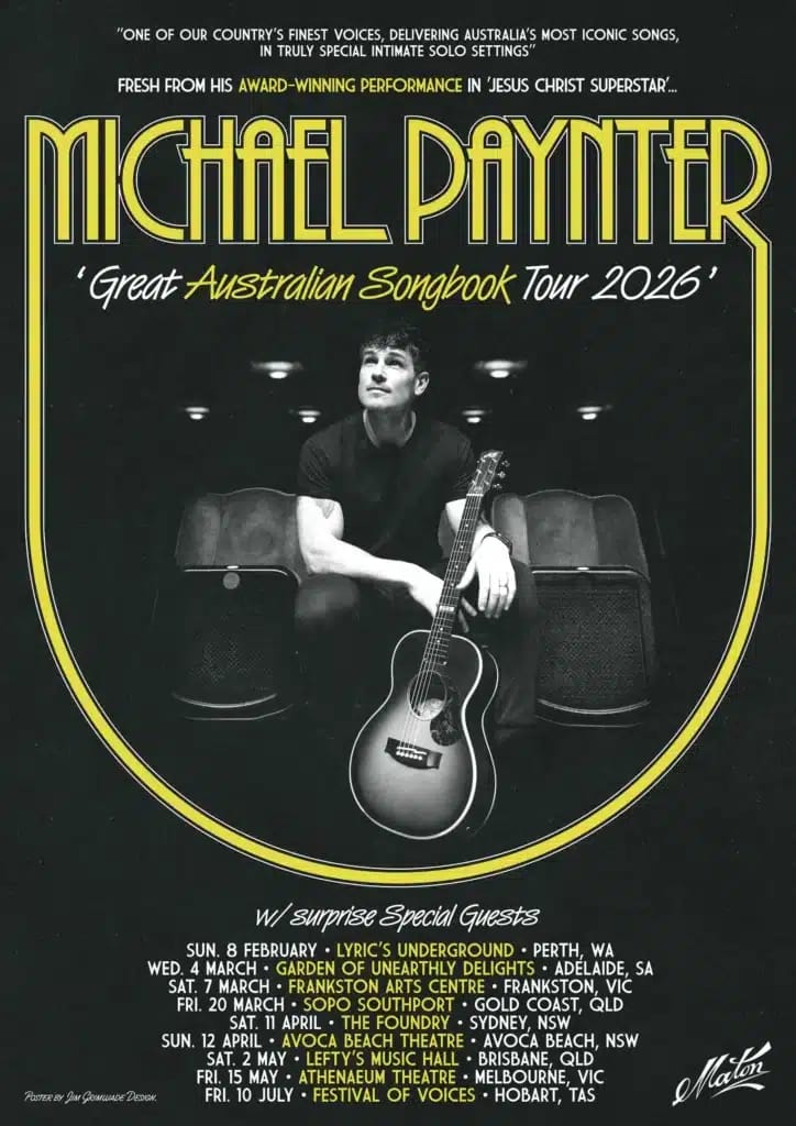 Solo performer seated with acoustic guitar under spotlights on dark stage for Great Australian Songbook Tour 2026.
