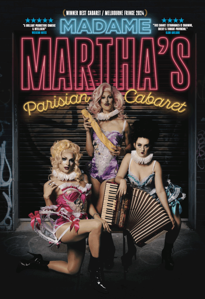 Three performers in cabaret costume pose with musical instruments beneath neon signage for Madame Martha's Parisian Cabaret.