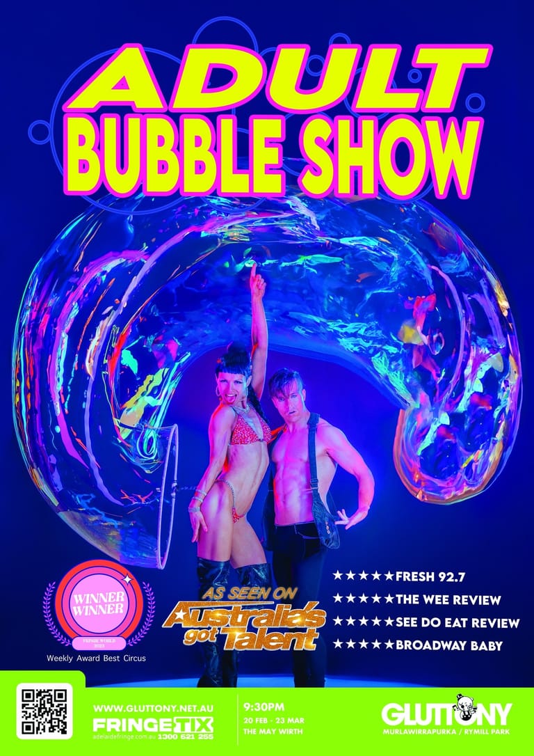 Performers in neon-lit costumes pose inside a luminous blue bubble against a dark blue backdrop.