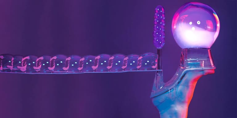 A glowing bubble wand with illuminated sphere against purple-lit stage backdrop.