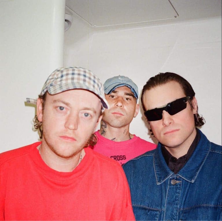 Three performers in casual attire pose together in a portrait-style shot.