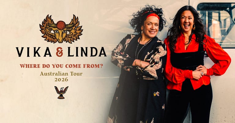 Two performers pose together against a tour promotional backdrop, one in black leather and one in a red jacket.