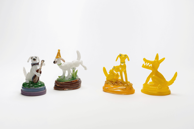 Four colourful decorative figurines arranged in a row against a white background.
