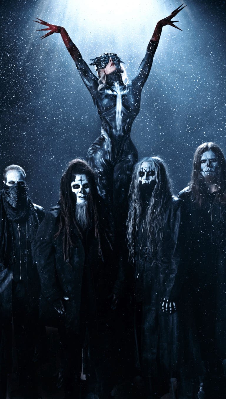 Theatrical figure with arms raised stands elevated above four band members in dark costumes against a starlit blue background.