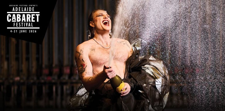 Shirtless performer mid-song under stage spotlights, holding props, at the Adelaide Cabaret Festival Opening Gala.