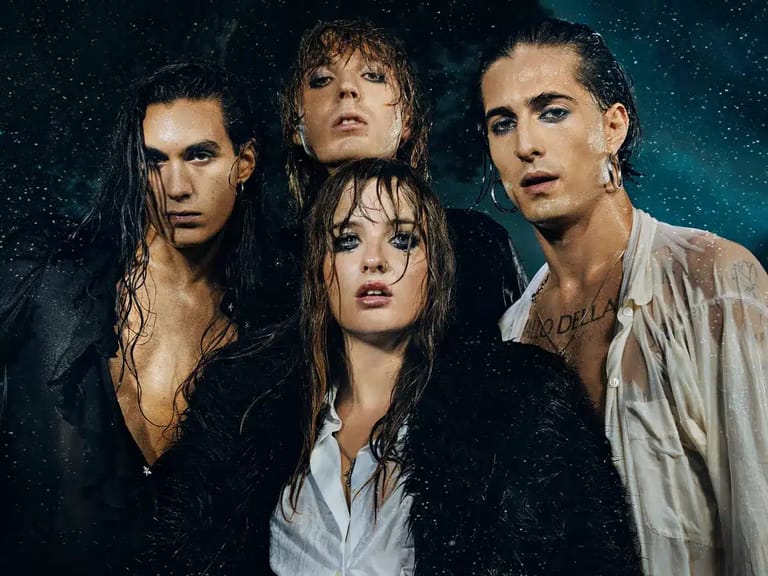 Four band members posed against a dark, starlit background with dramatic lighting.