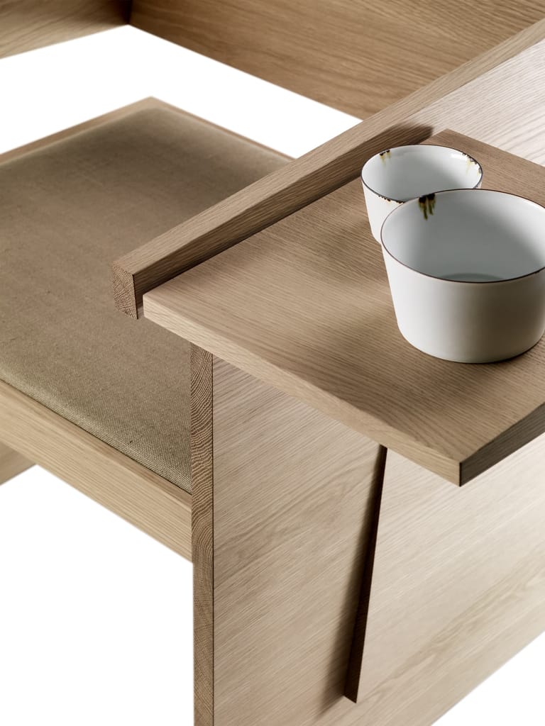 Light timber desk with white ceramic vessels and a recessed pull detail on the drawer.